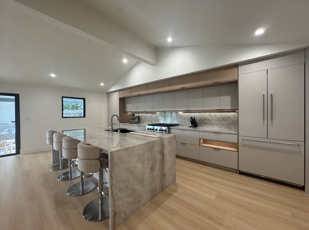 A finished renovation: vaulted ceiling, flat-panel cabinetry and a full-slab stone island